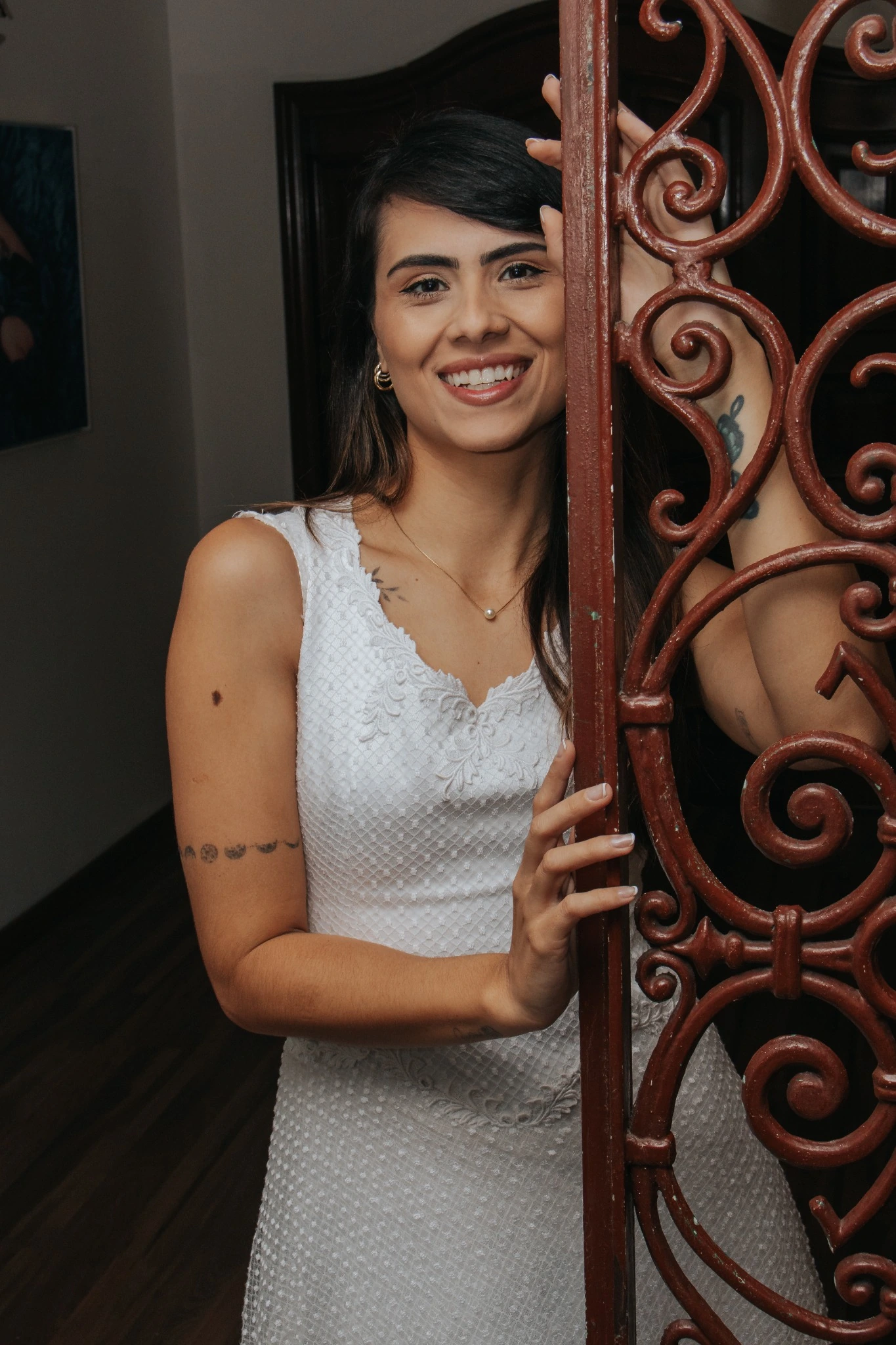Giovana sorrindo junto a uma estrutura decorativa durante o ensaio