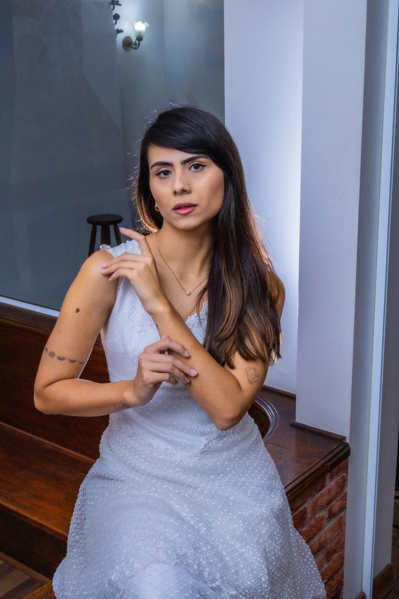 Giovana sentada com vestido de noiva durante o ensaio