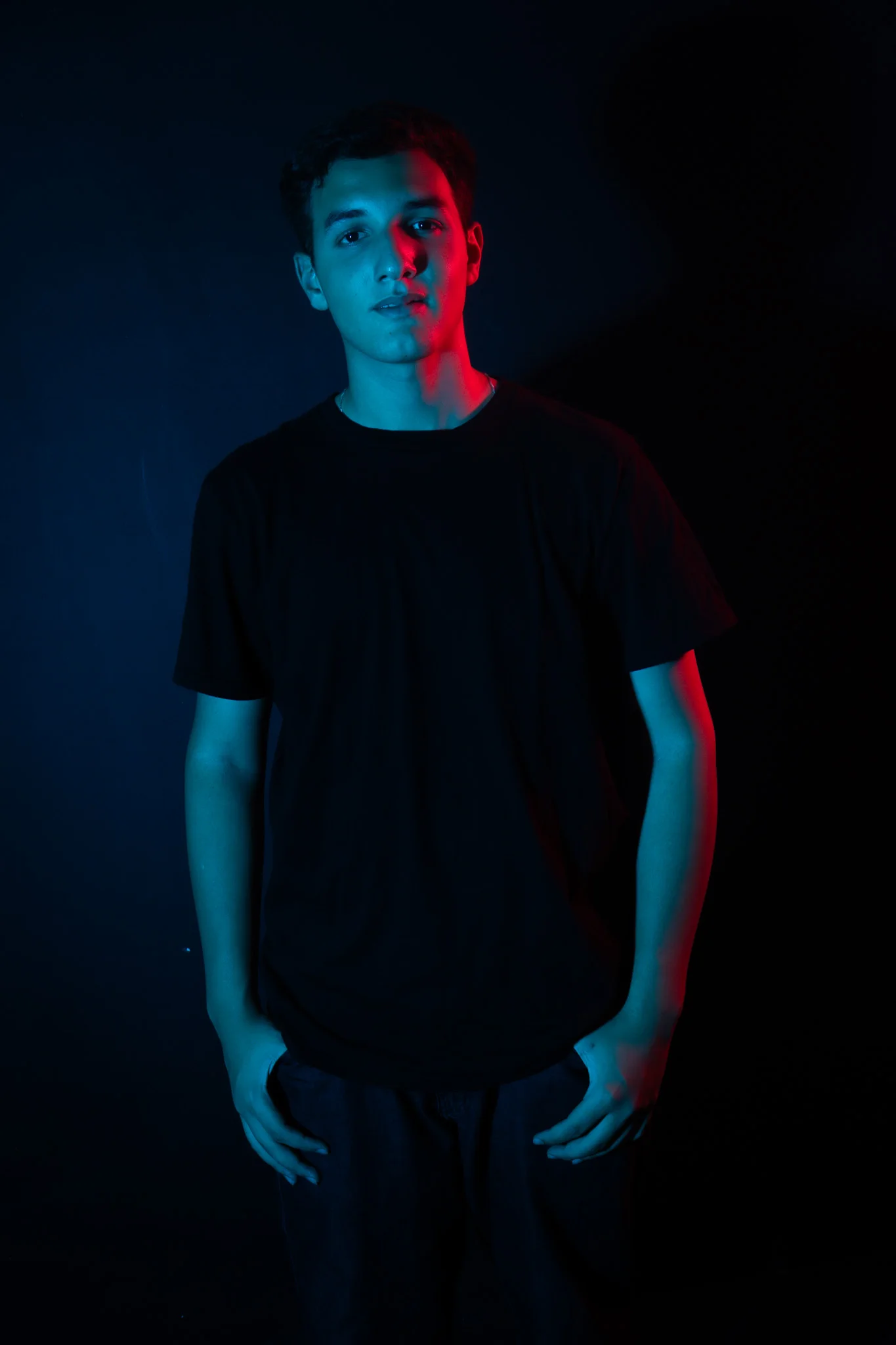 Retrato de Vinicius com iluminação dramática azul e vermelha